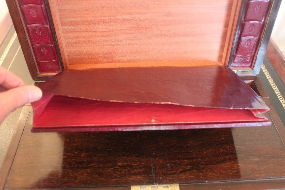 A rectangular dark rosewood writing slope box with brass corner mounts, brass cartouche inlay, and a central brass keyhole with a tassel. View VIII