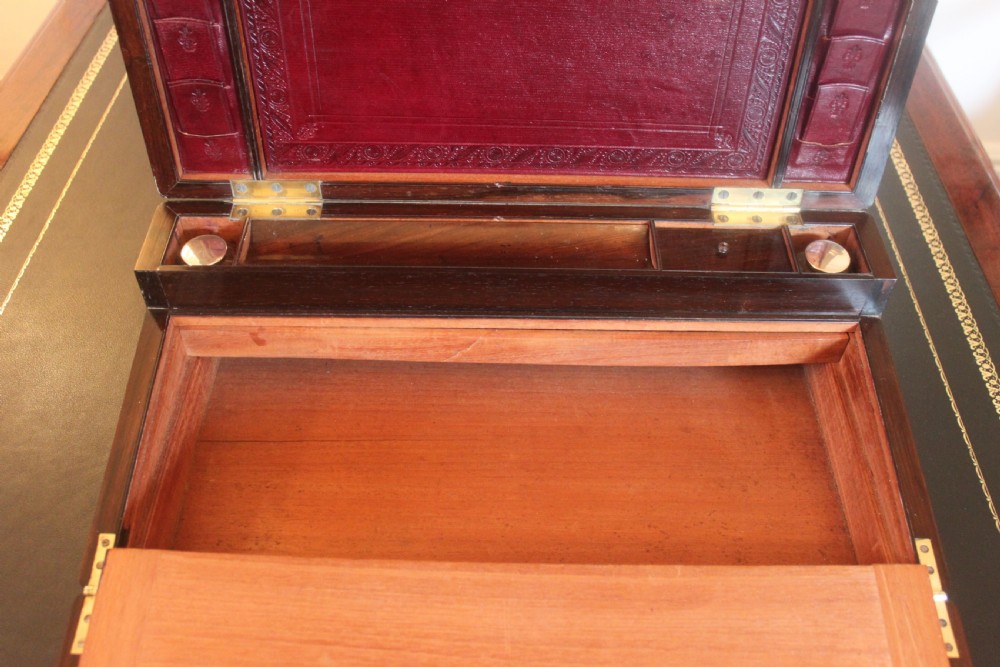 A rectangular dark rosewood writing slope box with brass corner mounts, brass cartouche inlay, and a central brass keyhole with a tassel. View X