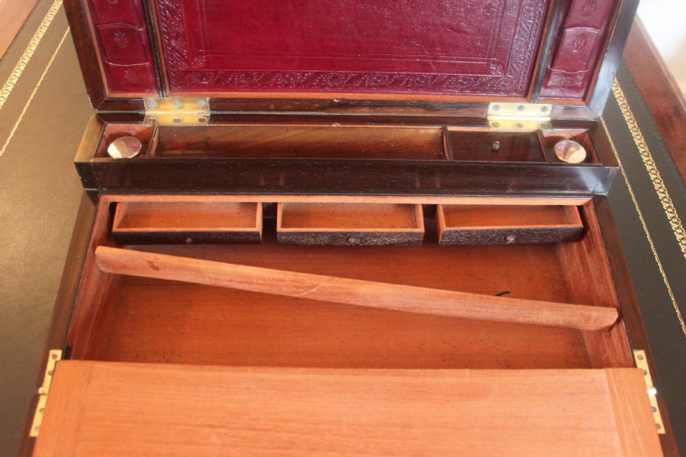 A rectangular dark rosewood writing slope box with brass corner mounts, brass cartouche inlay, and a central brass keyhole with a tassel. View XI