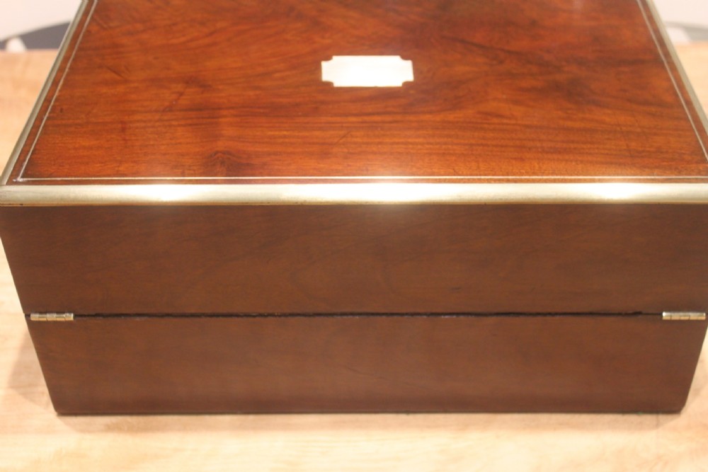 A dark walnut rectangular writing slope with brass edge binding, an inset brass plaque on top, and a brass escutcheon with key. View III