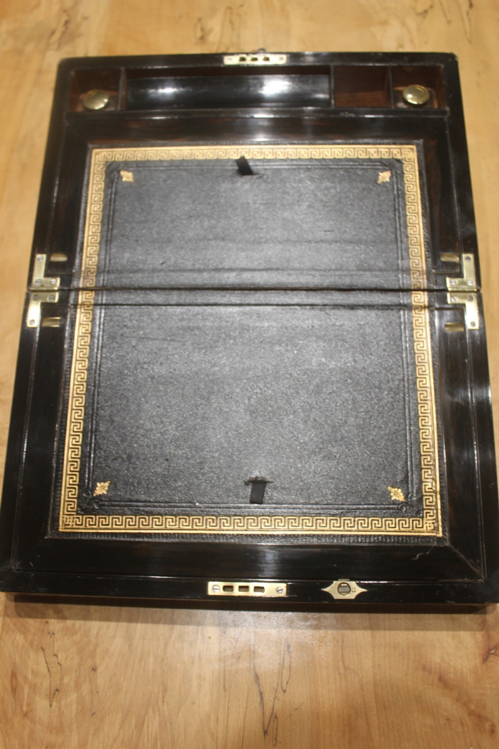 A dark walnut rectangular writing slope with brass edge binding, an inset brass plaque on top, and a brass escutcheon with key. View V