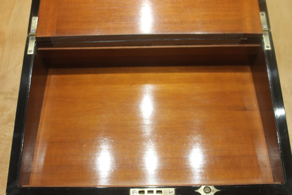A dark walnut rectangular writing slope with brass edge binding, an inset brass plaque on top, and a brass escutcheon with key. View VII