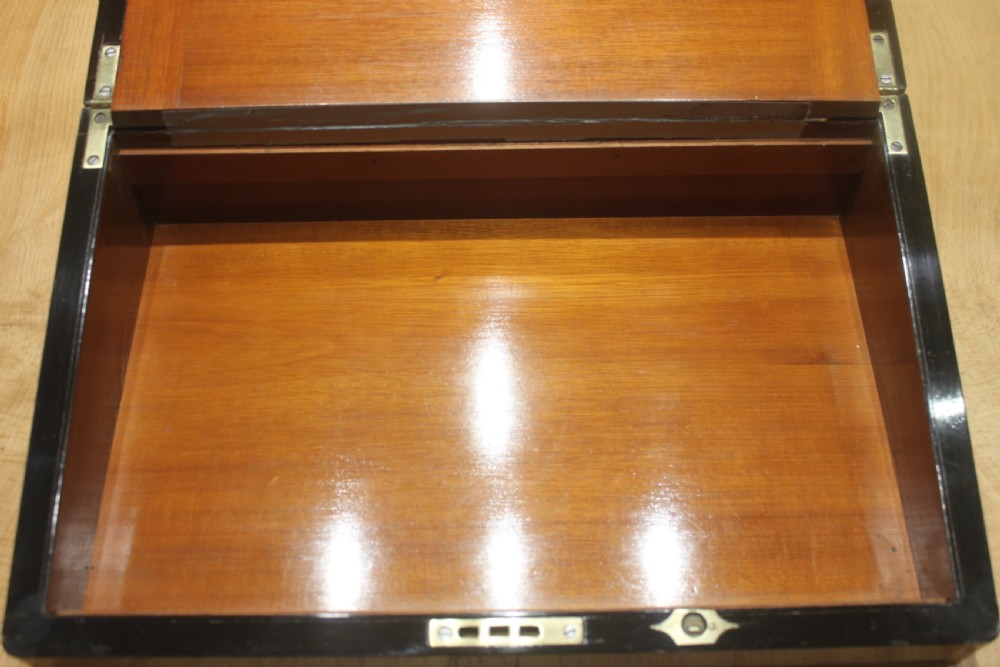 A dark walnut rectangular writing slope with brass edge binding, an inset brass plaque on top, and a brass escutcheon with key. View VIII