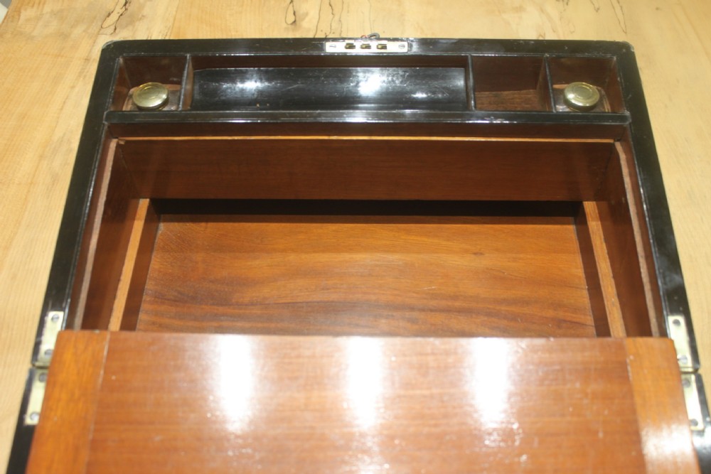 A dark walnut rectangular writing slope with brass edge binding, an inset brass plaque on top, and a brass escutcheon with key. View IX