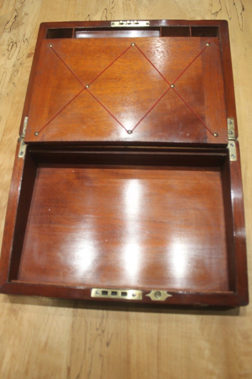 A closed mahogany campaign writing slope featuring brass corner brackets, brass banding, and a central brass cartouche with a key in the escutcheon. View IX