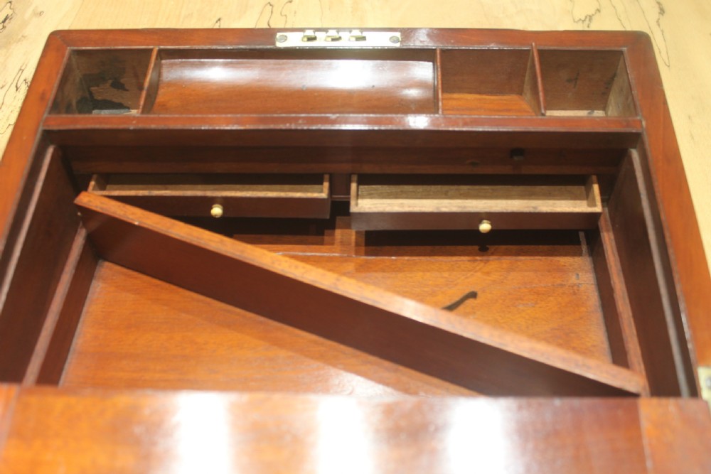 A closed mahogany campaign writing slope featuring brass corner brackets, brass banding, and a central brass cartouche with a key in the escutcheon. View XI
