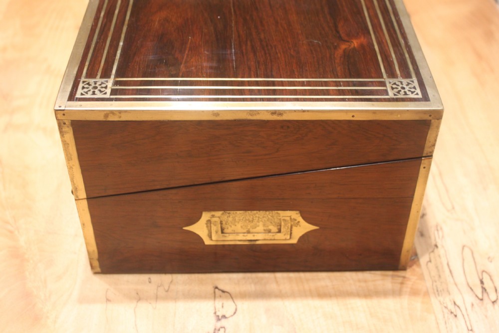 A late Georgian dark rosewood writing slope box decorated with geometric brass stringing, corner details, and a central brass cartouche. View II