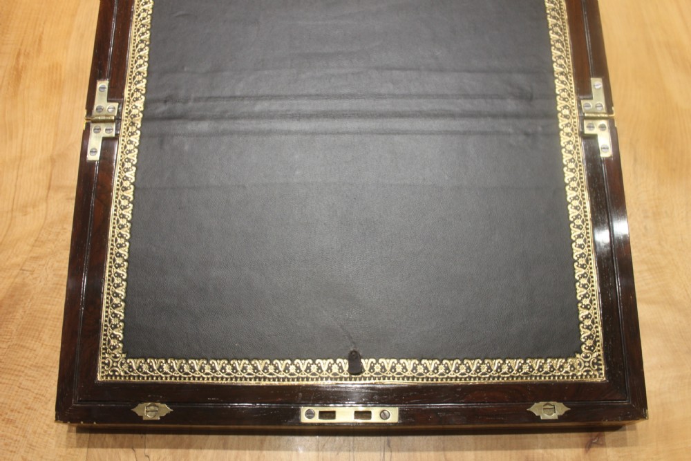 A late Georgian dark rosewood writing slope box decorated with geometric brass stringing, corner details, and a central brass cartouche. View VII
