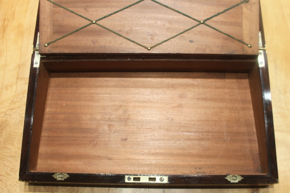 A late Georgian dark rosewood writing slope box decorated with geometric brass stringing, corner details, and a central brass cartouche. View VIII