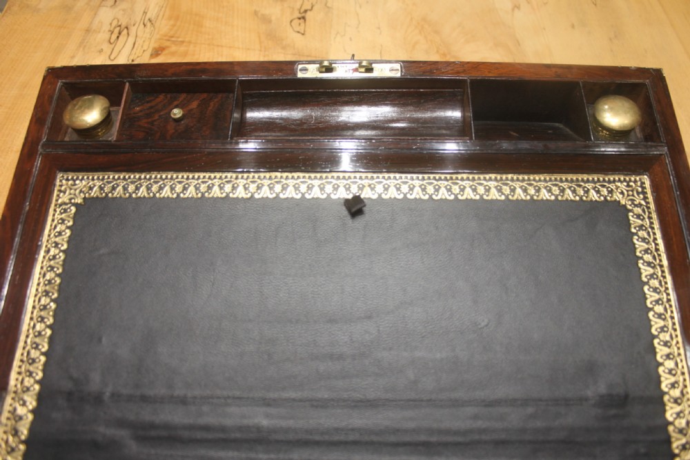 A late Georgian dark rosewood writing slope box decorated with geometric brass stringing, corner details, and a central brass cartouche. View IX
