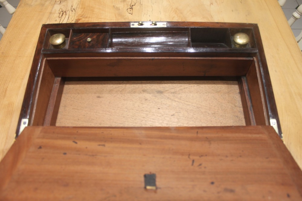 A late Georgian dark rosewood writing slope box decorated with geometric brass stringing, corner details, and a central brass cartouche. View X