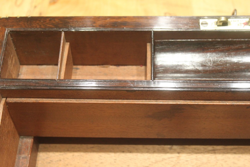 A late Georgian dark rosewood writing slope box decorated with geometric brass stringing, corner details, and a central brass cartouche. View XII