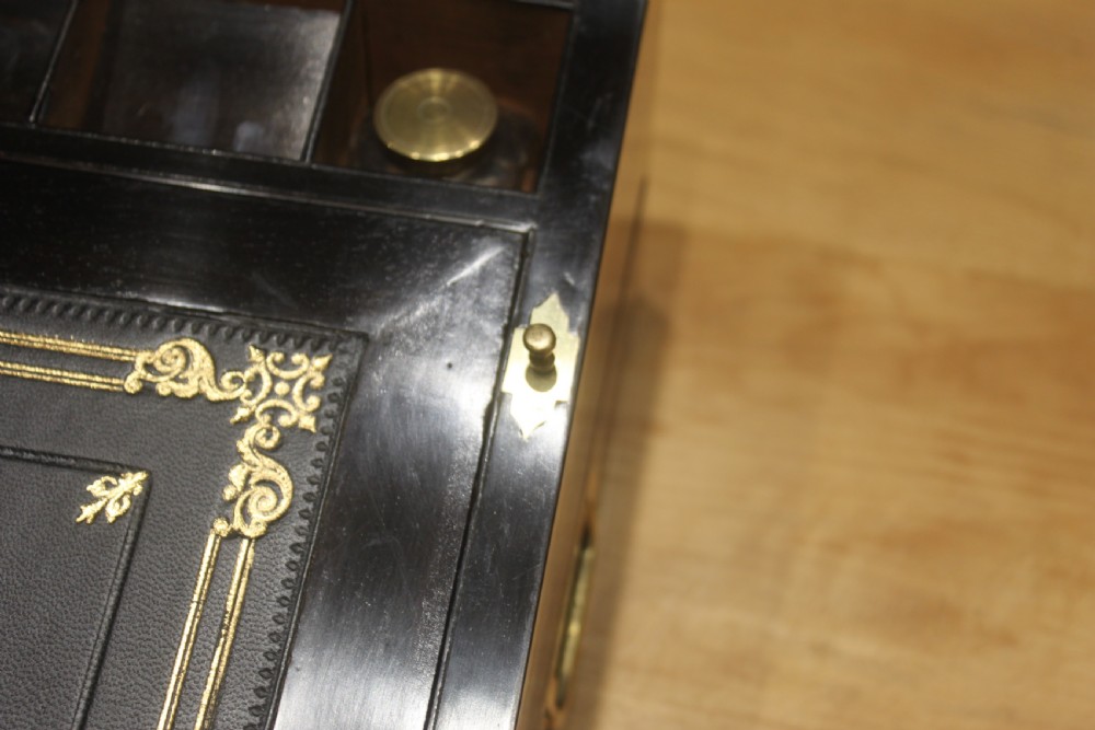 A rectangular figured walnut writing slope decorated with brass corner brackets, brass strapping, a blank central brass cartouche, and a keyhole escutcheon. View VI