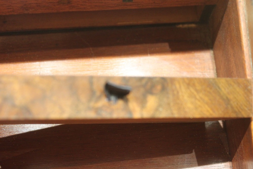 A rectangular figured walnut writing slope decorated with brass corner brackets, brass strapping, a blank central brass cartouche, and a keyhole escutcheon. View XIV