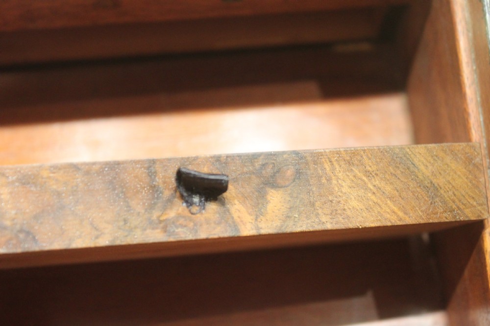 A rectangular figured walnut writing slope decorated with brass corner brackets, brass strapping, a blank central brass cartouche, and a keyhole escutcheon. View XV