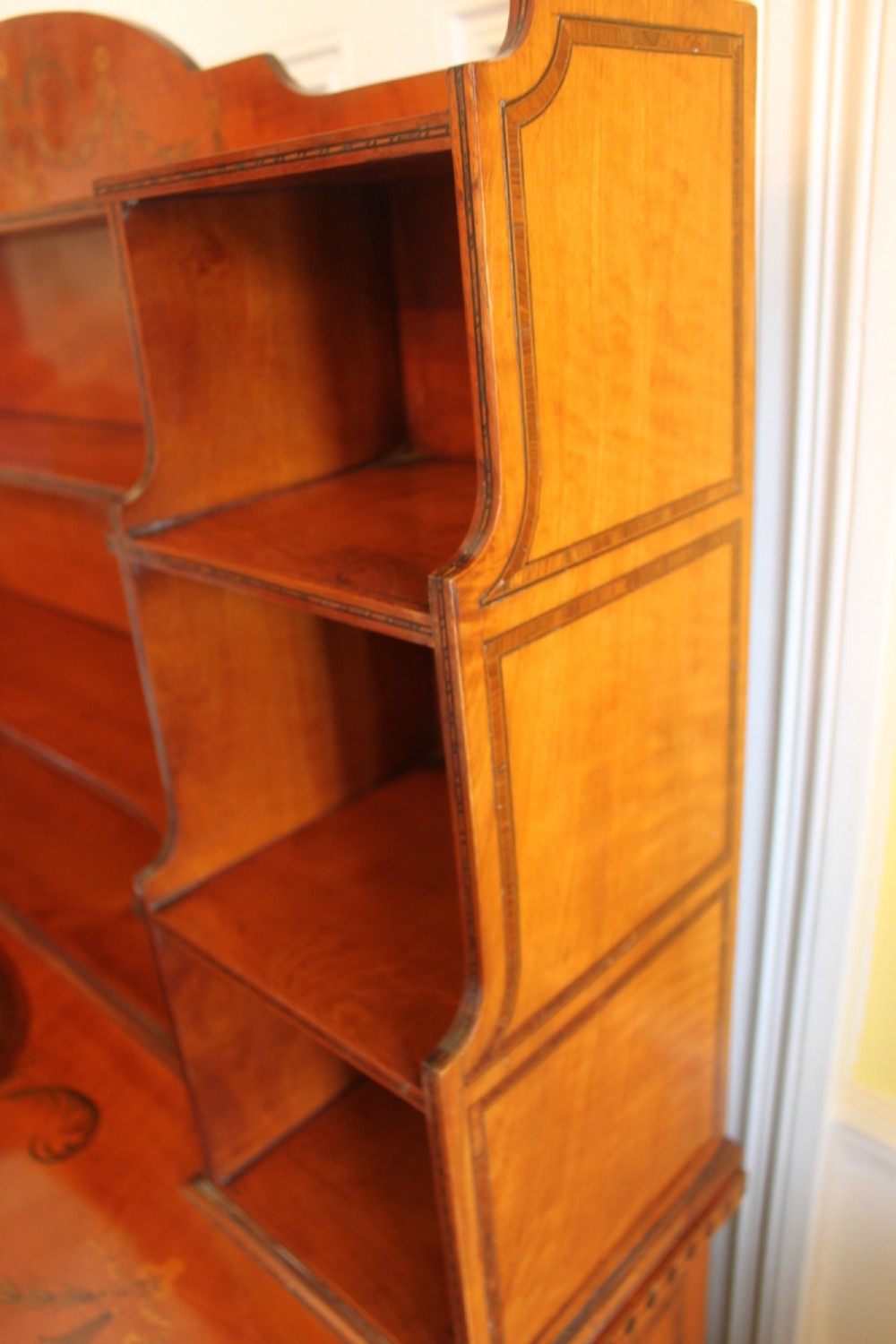 An antique Sheraton style satinwood cabinet with an open tiered shelving top unit and a lower two-door cabinet featuring oval inlaid marquetry panels. View VIII