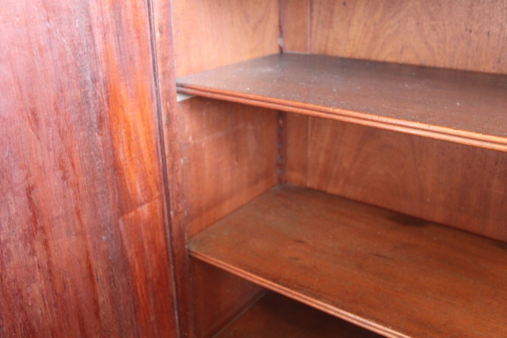 An antique Sheraton style satinwood cabinet with an open tiered shelving top unit and a lower two-door cabinet featuring oval inlaid marquetry panels. View XII