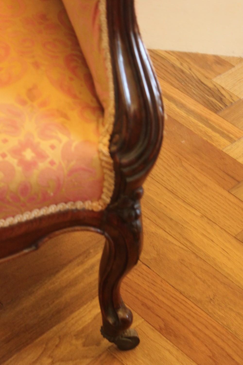An early Victorian balloon-back gentlemans armchair with a carved dark mahogany frame, button-backed yellow damask upholstery, and cabriole legs. View VII