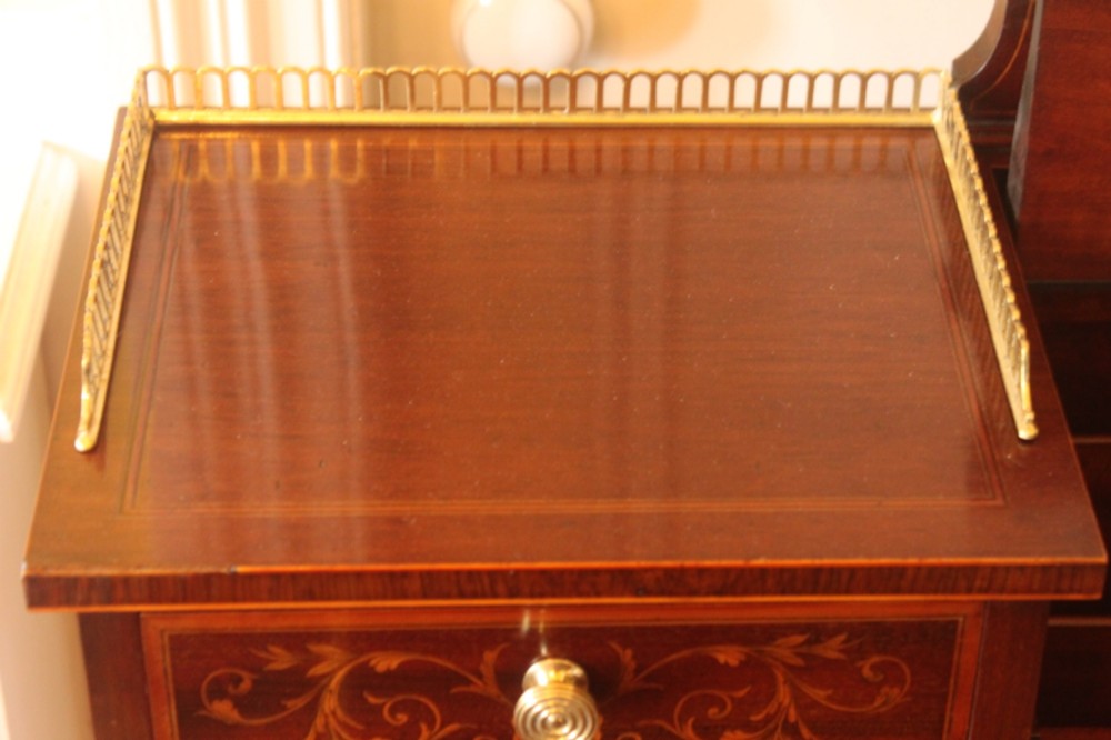 A Sheraton Revival mahogany writing desk featuring intricate marquetry inlays, a brown leather writing surface, a raised superstructure with small drawers, and square tapered legs. View X