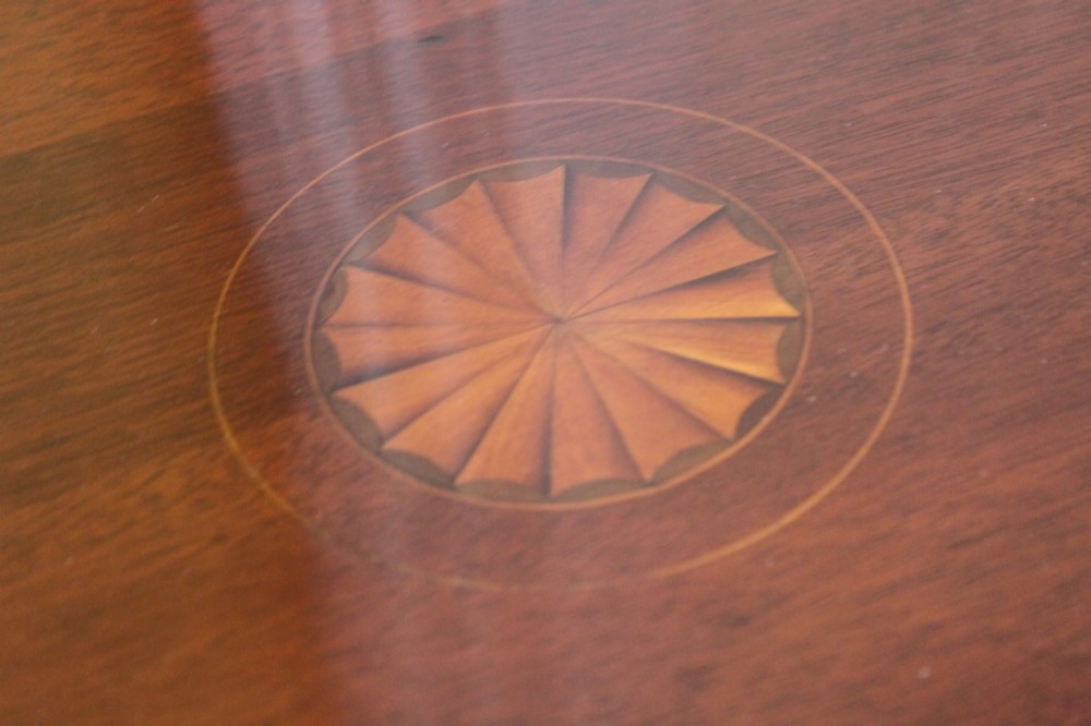 A circular Edwardian mahogany occasional table featuring satinwood starburst inlay and a lower tier on slender splayed legs. View V