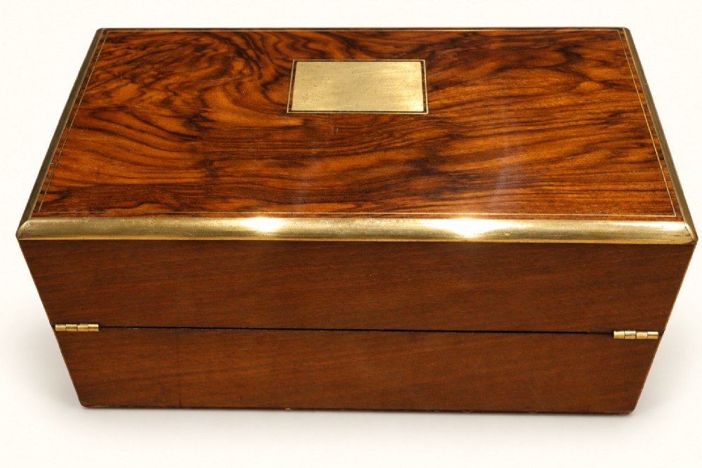 A rectangular Victorian rosewood writing slope featuring brass-bound edges, an inlaid central brass plaque, and a key with a tassel in a brass Bramah lock. View III