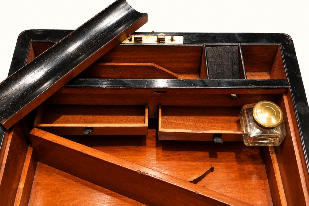 A rectangular Victorian rosewood writing slope featuring brass-bound edges, an inlaid central brass plaque, and a key with a tassel in a brass Bramah lock. View IX