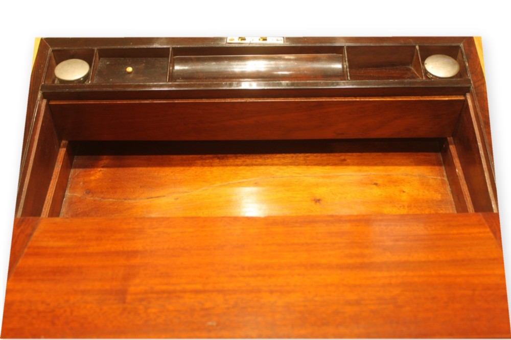 A closed rectangular dark rosewood writing slope box featuring detailed brass foliate inlay along the borders and a brass key inserted into the front lock. View IX