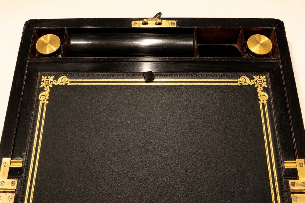 An antique curl grain mahogany writing slope with fine brass stringing inlay, a decorative central brass cartouche, and a brass key inserted in the escutcheon. View VII