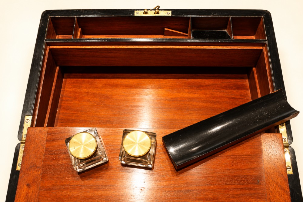 An antique curl grain mahogany writing slope with fine brass stringing inlay, a decorative central brass cartouche, and a brass key inserted in the escutcheon. View VIII