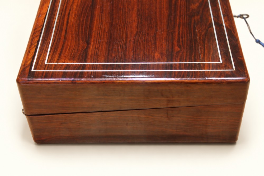 A rectangular dark rosewood wooden writing slope featuring double brass stringing inlay, a central brass cartouche, and an escutcheon with an inserted key. View III