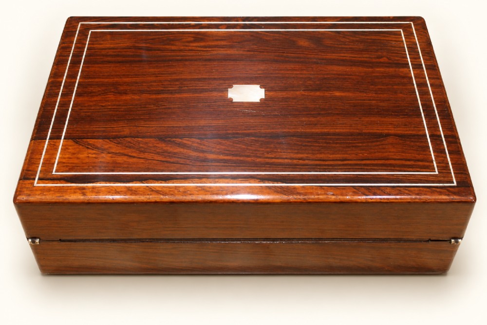 A rectangular dark rosewood wooden writing slope featuring double brass stringing inlay, a central brass cartouche, and an escutcheon with an inserted key. View IV