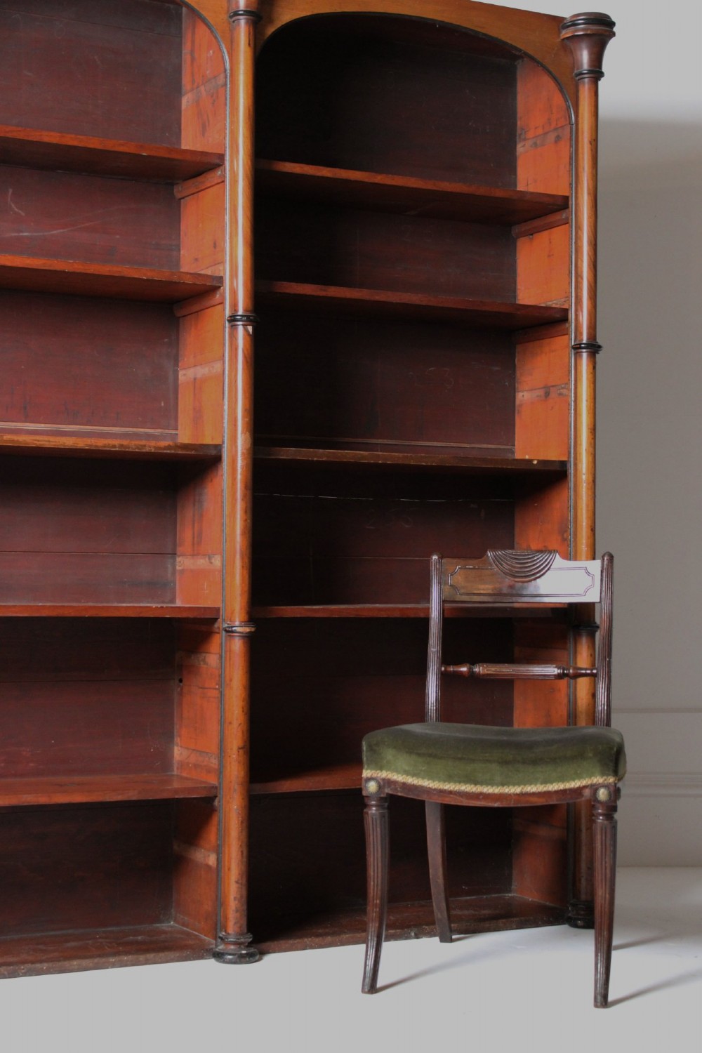A large 19th-century double-bay open timber bookcase with arched tops and turned column pilasters in a warm brown finish. View VI