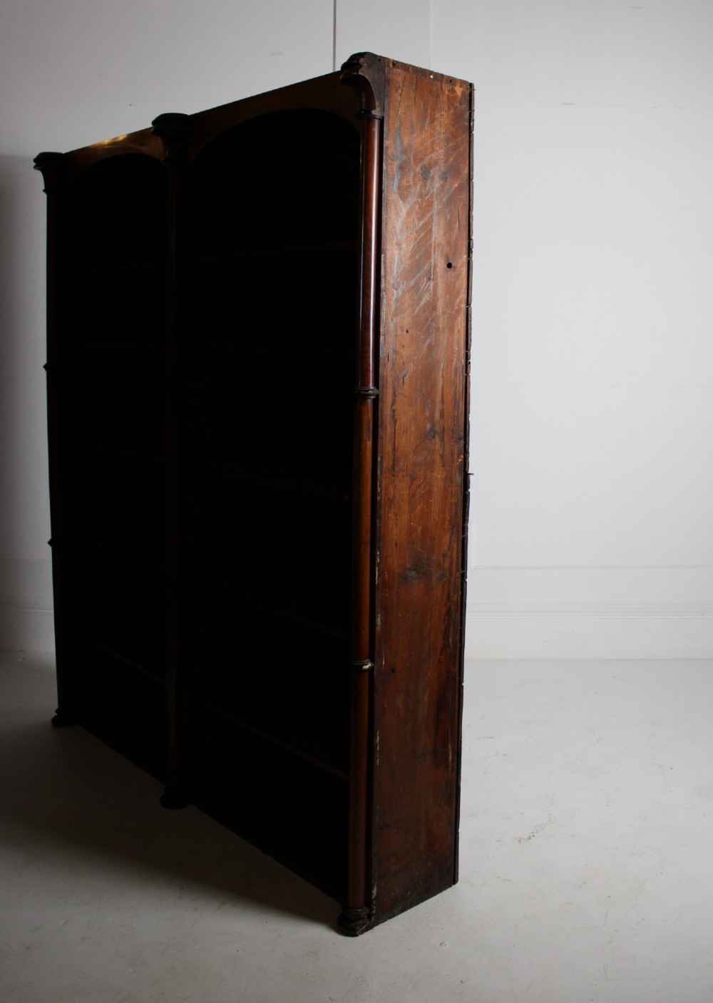 A large 19th-century double-bay open timber bookcase with arched tops and turned column pilasters in a warm brown finish. View VIII