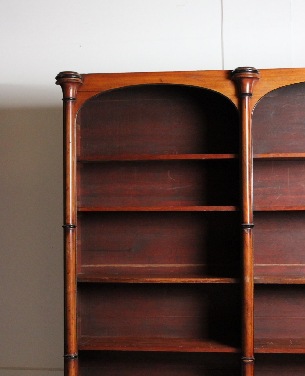 A large 19th-century double-bay open timber bookcase with arched tops and turned column pilasters in a warm brown finish. View XI