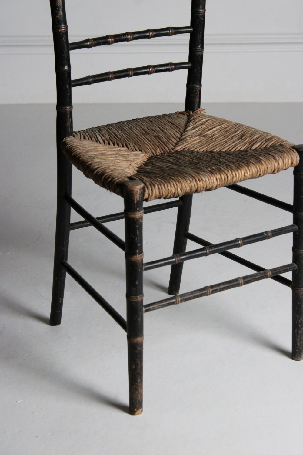 A late 19th-century ebonised side chair featuring turned faux bamboo detailing and a woven rush seat. View III