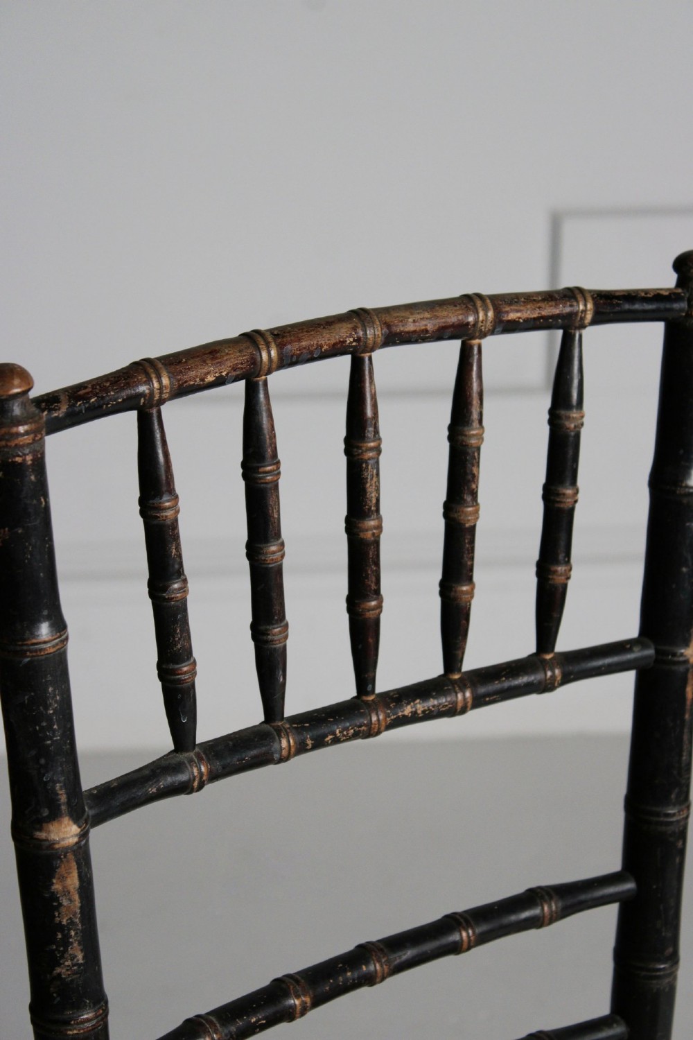 A late 19th-century ebonised side chair featuring turned faux bamboo detailing and a woven rush seat. View V