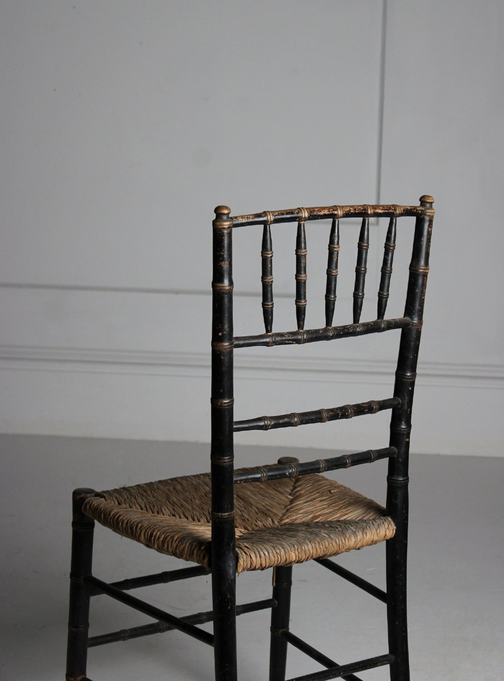 A late 19th-century ebonised side chair featuring turned faux bamboo detailing and a woven rush seat. View VII