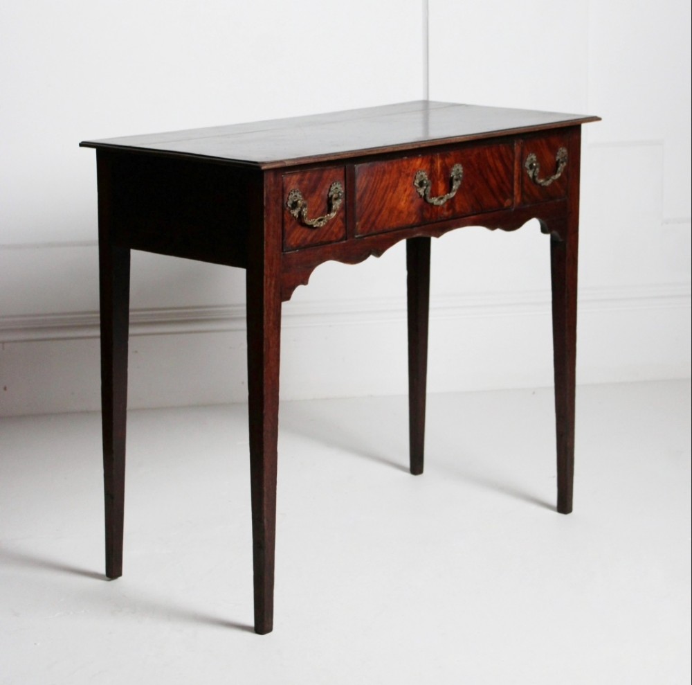An 18th-century Georgian mahogany side table with three frieze drawers, brass swan-neck handles, a shaped apron, and tapered square legs. View III