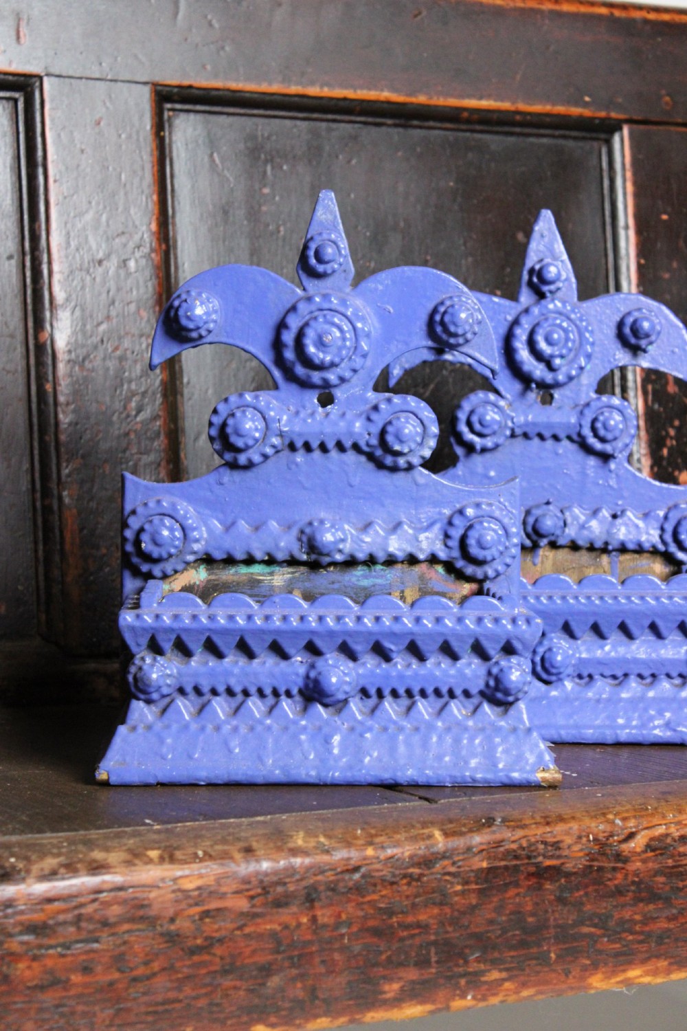 A pair of notch-carved wooden tramp art wall boxes painted in vivid blue with geometric chip-carved layers and crown pediments. View II