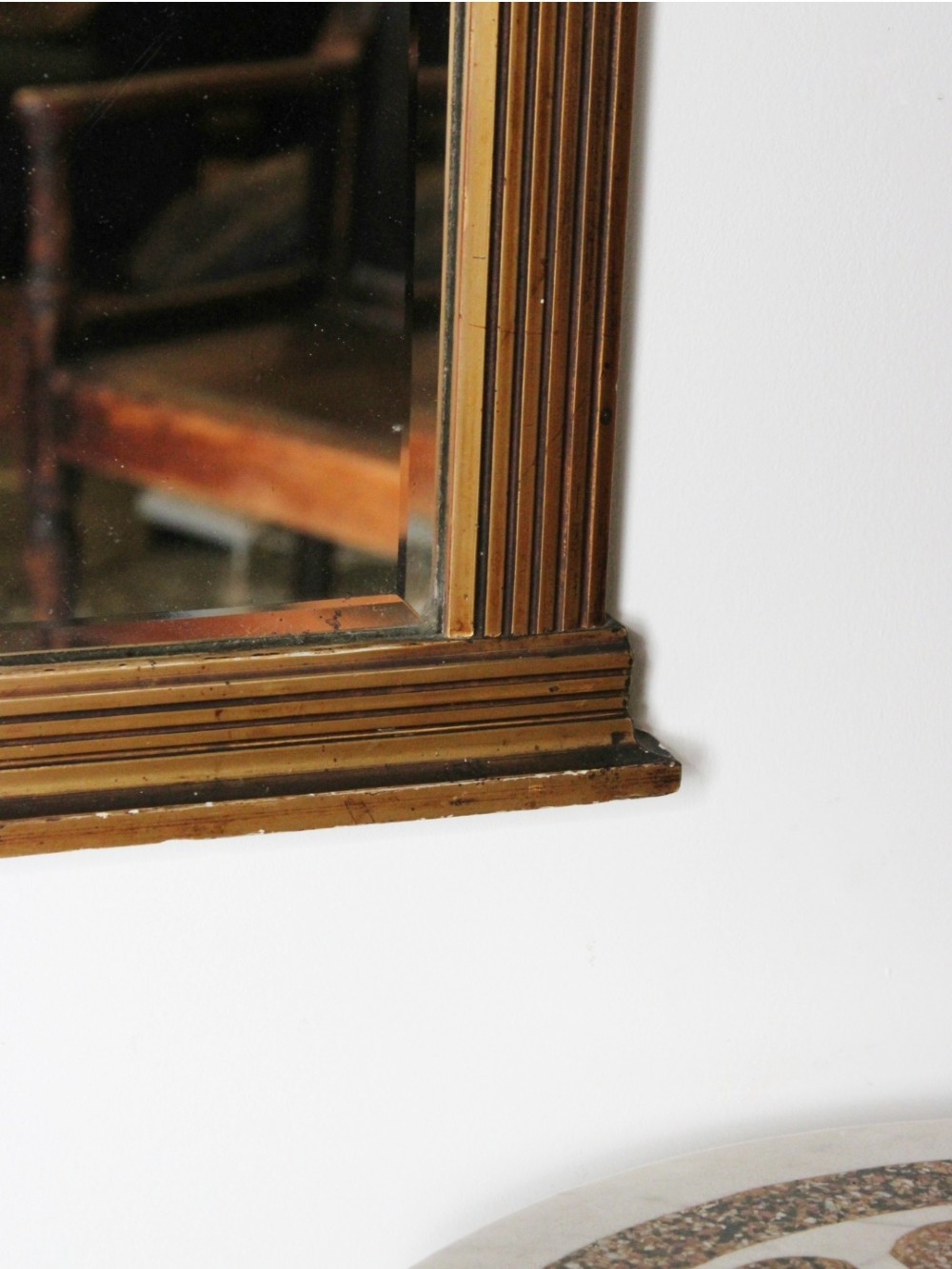 An early 19th century Regency giltwood pier mirror with reeded pilaster sides, a stepped architectural cornice, and foxed glass mirror plate. View V