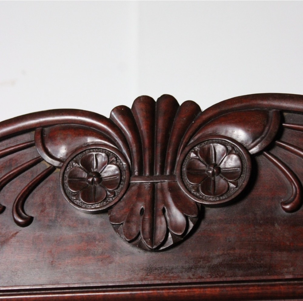 A nineteenth-century Victorian flame mahogany breakfront compactum wardrobe featuring a central chest of drawers flanked by two arched-panel cupboard doors beneath a carved central cresting. View III