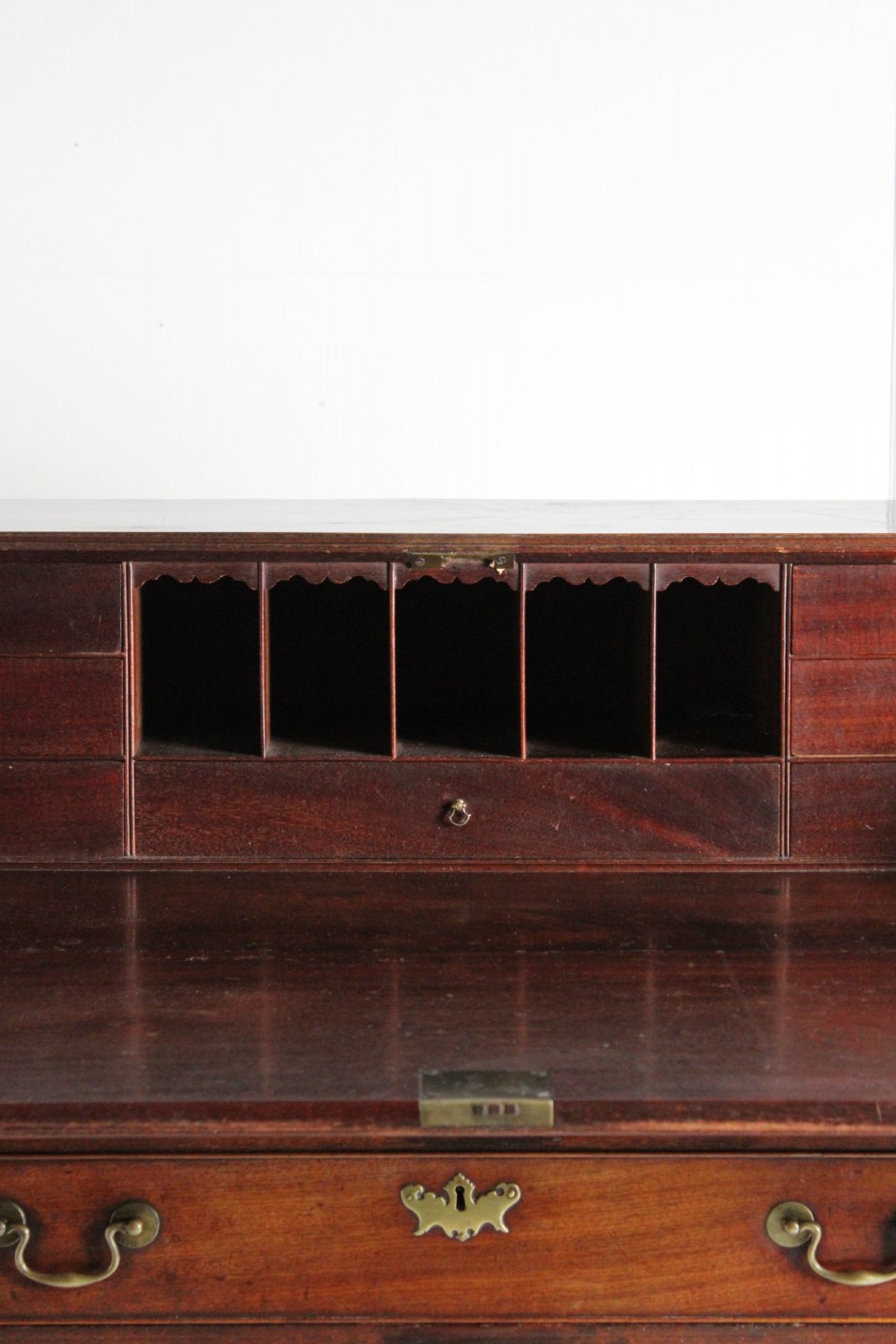 A George III mahogany fall front bureau featuring four graduated drawers with brass handles, resting on bracket feet. View V