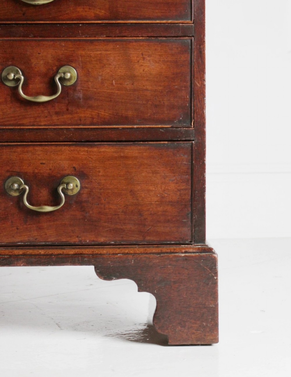 A George III mahogany fall front bureau featuring four graduated drawers with brass handles, resting on bracket feet. View IX