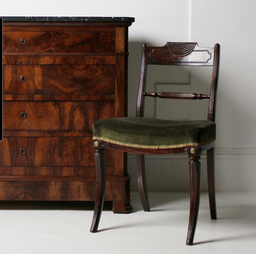 A Regency mahogany side chair with carved sabre legs, reeded frame, and olive green velvet upholstered seat with braid trim.