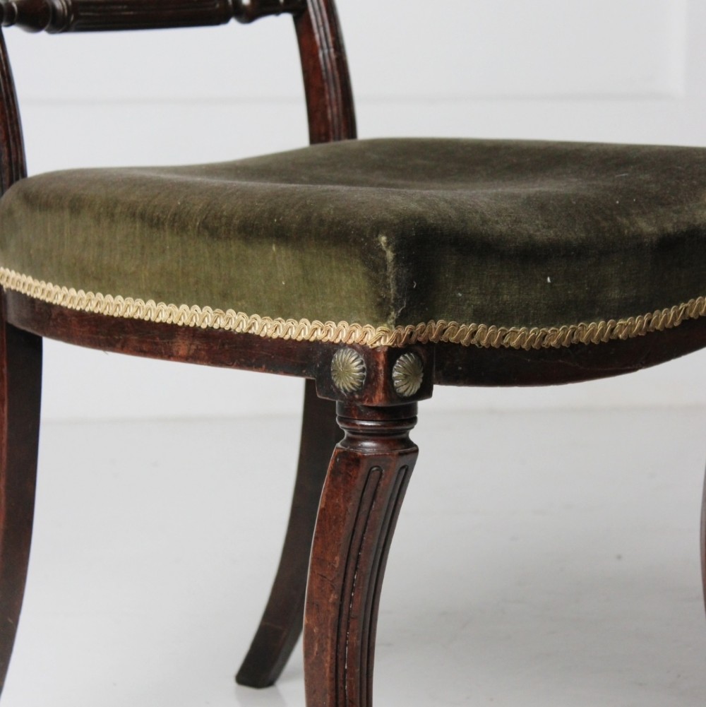 A Regency mahogany side chair with carved sabre legs, reeded frame, and olive green velvet upholstered seat with braid trim. View II