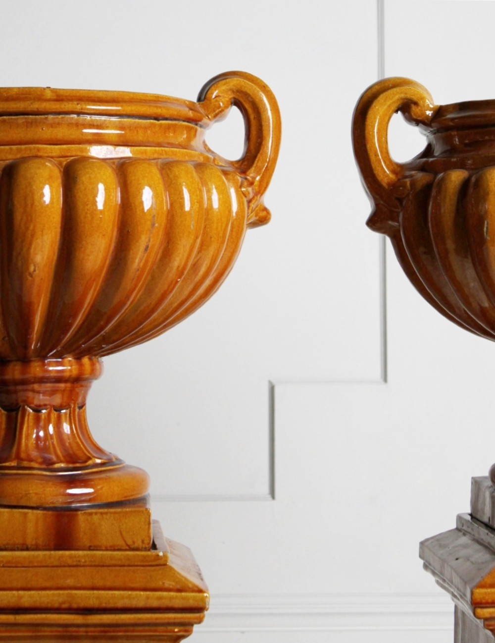 Large ochre glazed majolica urns on plinths View IV