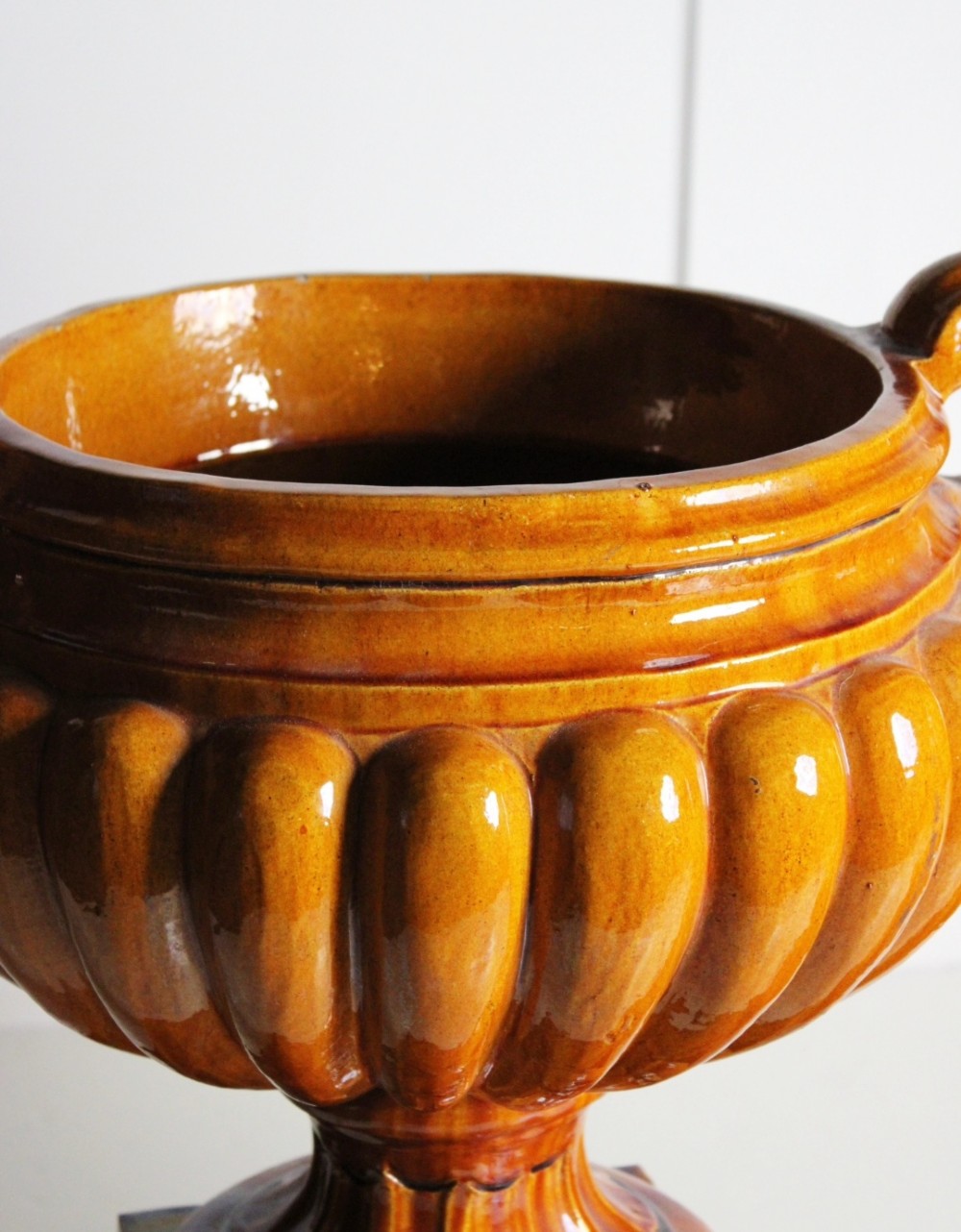 Large ochre glazed majolica urns on plinths View V