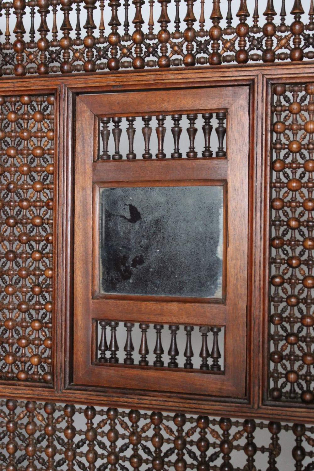 A four-panel dark hardwood folding screen featuring intricate geometric mashrabiya latticework panels above carved recessed bottom sections. View VIII