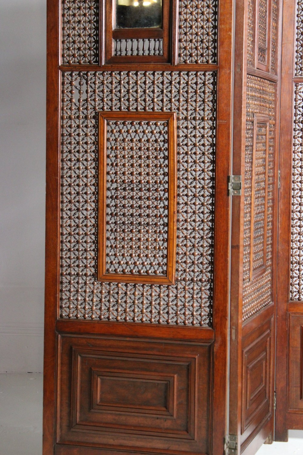 A four-panel dark hardwood folding screen featuring intricate geometric mashrabiya latticework panels above carved recessed bottom sections. View IX