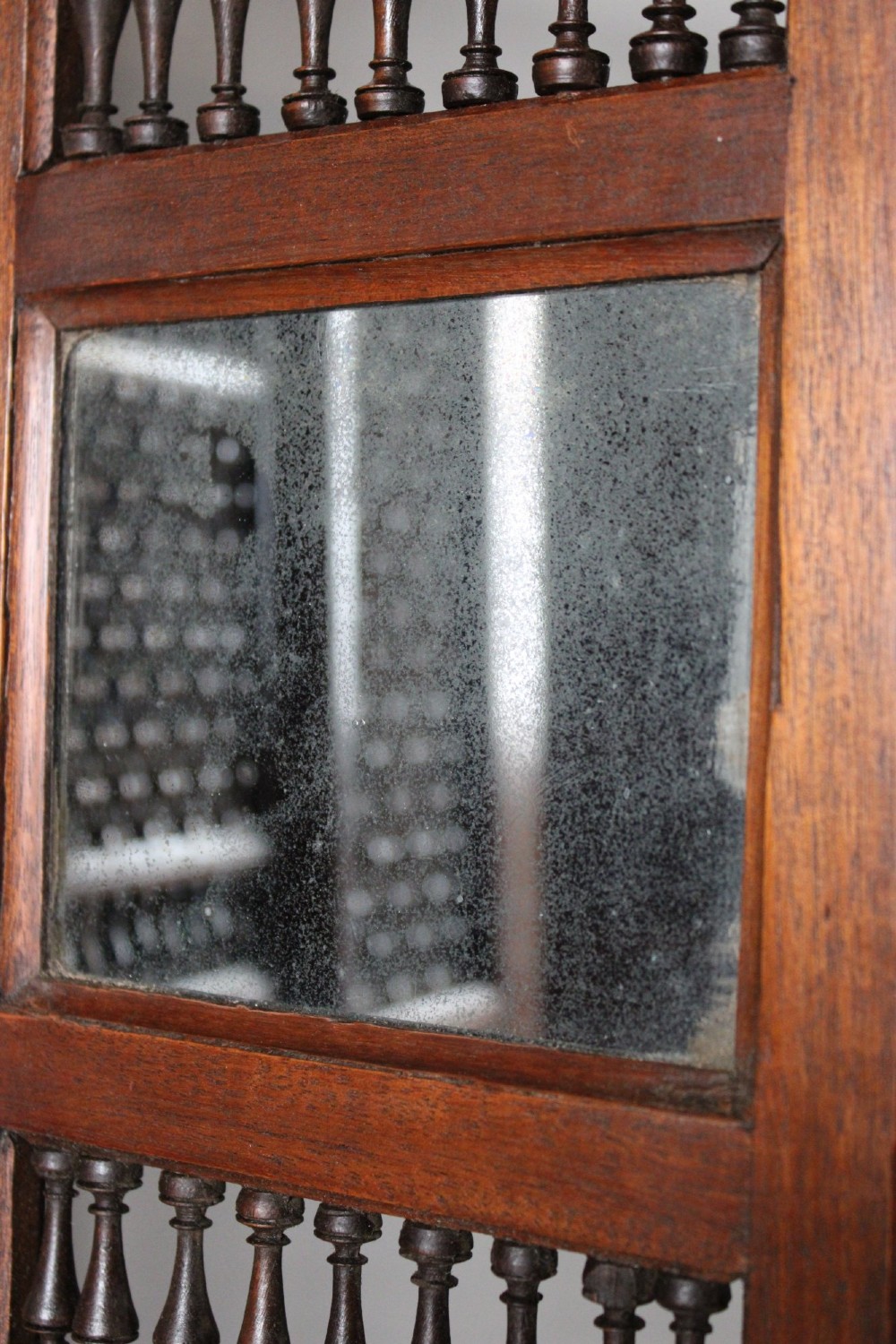 A four-panel dark hardwood folding screen featuring intricate geometric mashrabiya latticework panels above carved recessed bottom sections. View X
